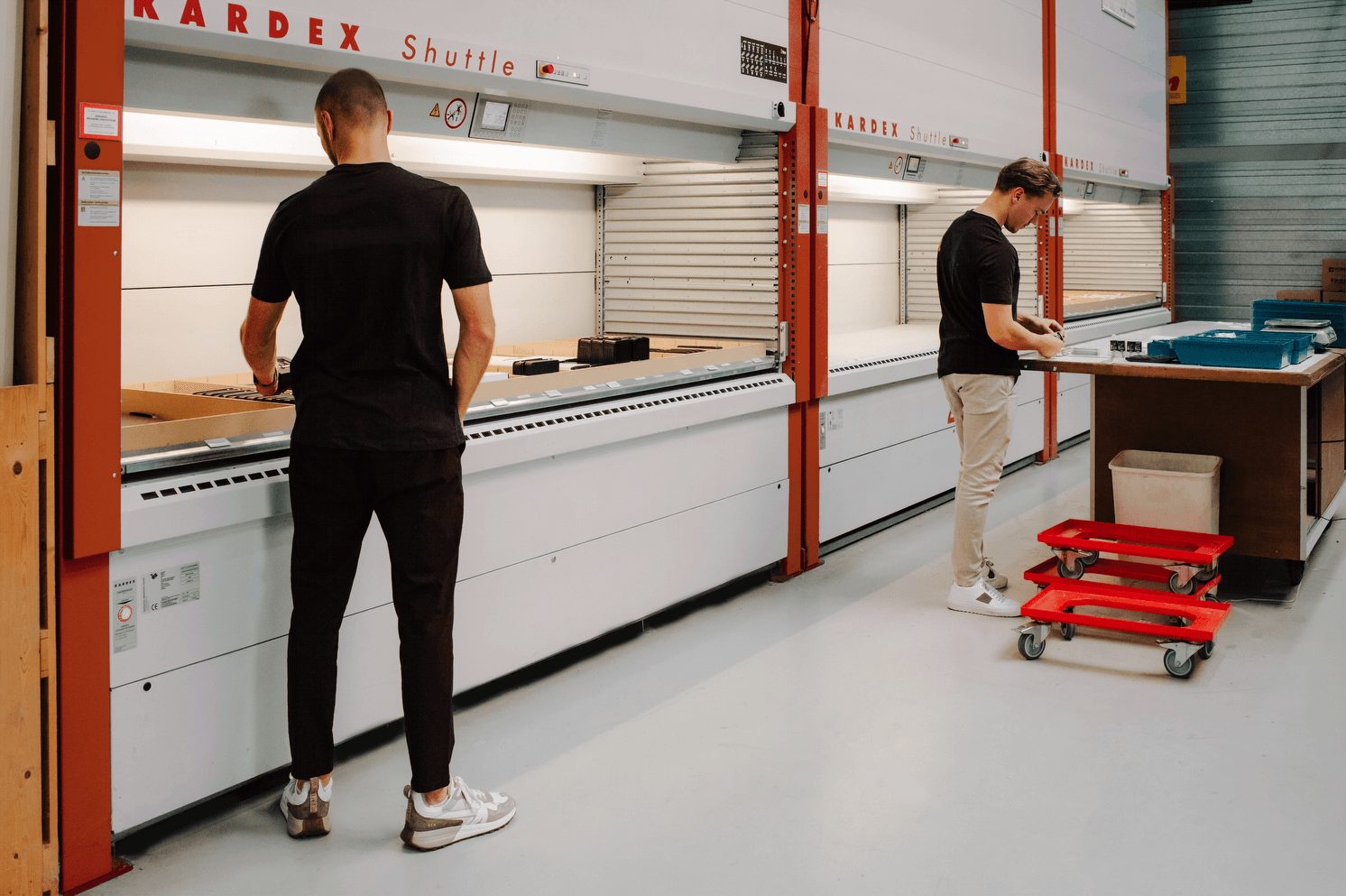 Medewerkers aan het werk bij de Kardex-opslagliften in het magazijn